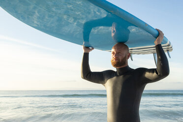 Spanien, Andalusien, Tarifa, Porträt eines Mannes mit Stand Up Paddle Board auf dem Meer - KBF00365