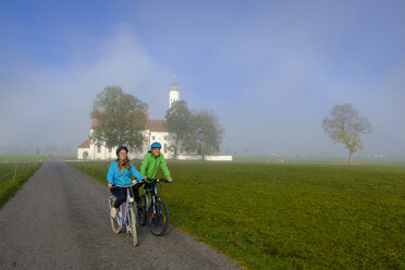 Germany, Pilgrimage Church St. Coloman and couple of cyclists on tour - LBF02332