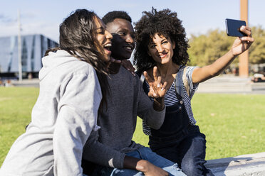 Three friends spending time in the city, taking selfies with a smartphone - GIOF05315