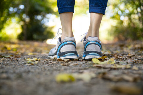 Nahaufnahme einer motivierten Frau, die auf einem herbstlichen Fußweg steht, lizenzfreies Stockfoto