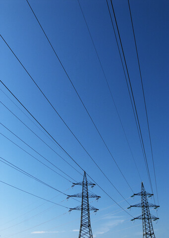 Power pylons under blue sky stock photo