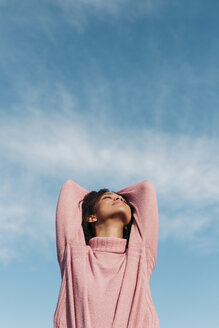 Relaxed young woman wearing pink turtleneck pullover enjoying fresh air - LOTF00031