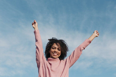 Portrait of smiling young woman against sky raising hands - LOTF00035