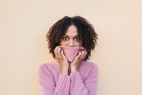 Porträt einer jungen Frau mit rosa Pullover in der Hauptrolle, lizenzfreies Stockfoto