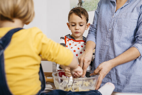 Porträt eines Jungen, der zusammen mit seiner Mutter und seiner kleinen Schwester Teig zubereitet - JRFF02333