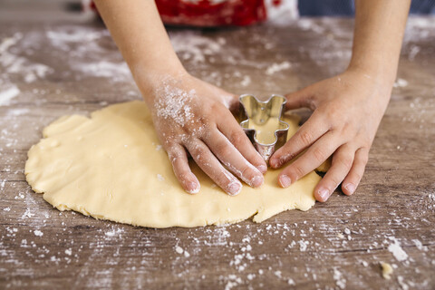 Jungenhände beim Ausstechen von Keksen, Nahaufnahme, lizenzfreies Stockfoto