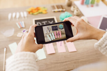 Top view of young woman taking photos with smartphone for her craft blog - JRFF02388