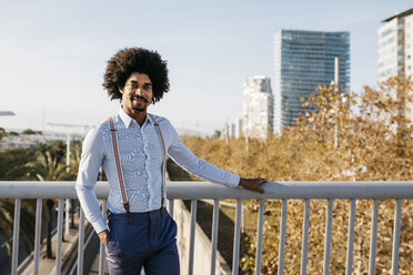 Spain, Barcelona, portrait of smiling man standing on a bridge - JRFF02402