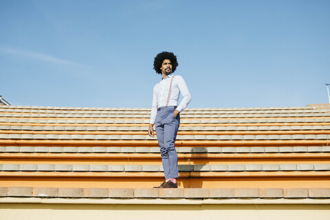 Stilvoller Mann auf einer Treppe stehend, lizenzfreies Stockfoto