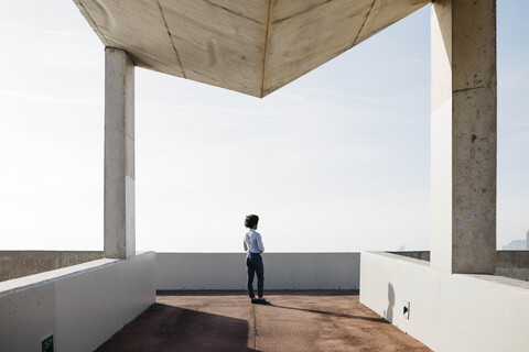 Spanien, Barcelona, Rückenansicht eines Mannes, der auf einer Brücke steht und die Aussicht betrachtet, lizenzfreies Stockfoto