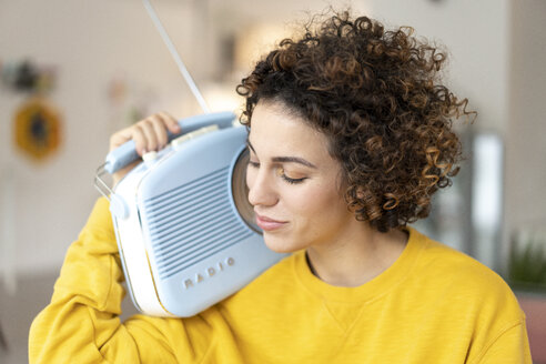 Frau hört zu Hause Musik mit tragbarem Radio - JOSF02689