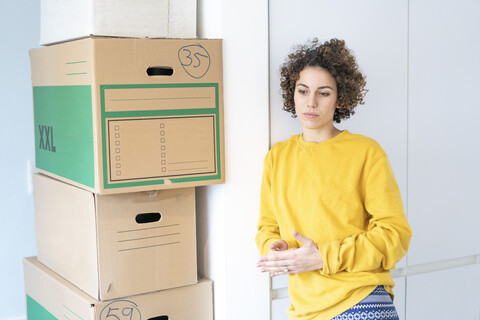 Ernste Frau zu Hause mit Pappkartons, lizenzfreies Stockfoto