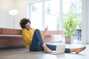 Woman using laptop, cell phone and tablet at home - JOSF02724