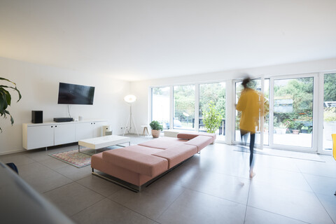 Woman moving in a spacious living room at home stock photo