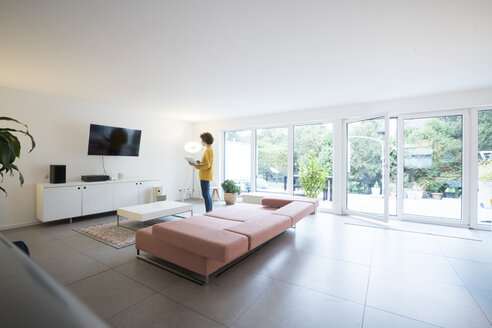 Woman using laptop in a spacious living room at home - JOSF02727