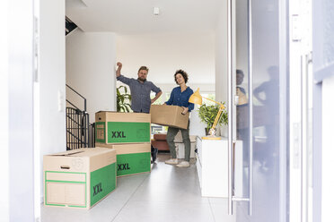 Portrait of couple in new home with cardboard boxes - JOSF02745