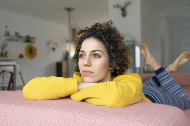 Woman lying on couch at home thinking - JOSF02756
