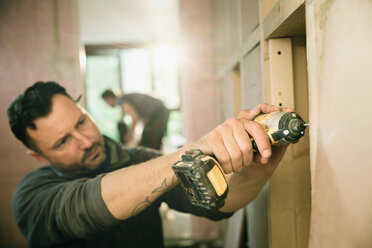 Focused construction worker using power drill - HOXF04249