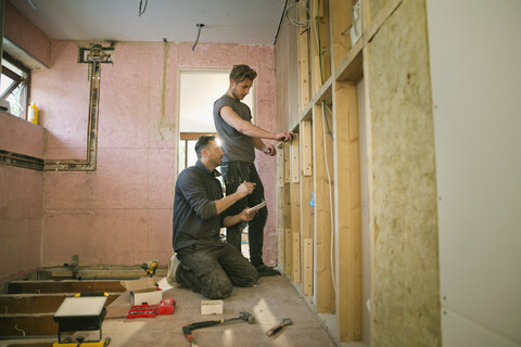 Bauarbeiter, die das Innere eines Hauses einrahmen, lizenzfreies Stockfoto