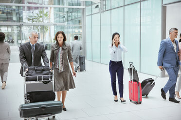 Business people with luggage in airport - HOXF04280