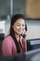 Lächelnde Geschäftsfrau beim Telefonieren im Büro - HOXF04292