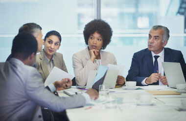 Attentive business people listening in conference room meeting - HOXF04305