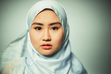 Porträt einer selbstbewussten, ernsten jungen Frau, die einen blauen Hidschab aus Seide trägt - CAIF22403