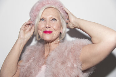 Porträt einer selbstbewussten, glamourösen älteren Frau mit rosa Pelz - CAIF22412