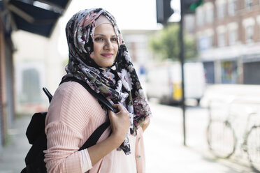 Porträt selbstbewusste Frau in geblümtem Hijab auf städtischem Bürgersteig - CAIF22422
