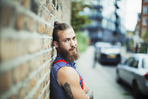 Selbstbewusster männlicher Hipster auf städtischem Bürgersteig, lizenzfreies Stockfoto