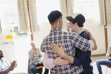 Men hugging in group therapy - CAIF22544