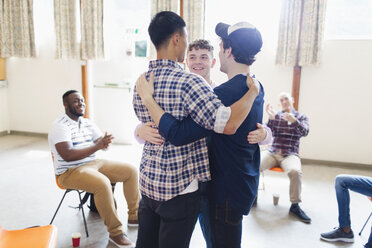 Men hugging in group therapy - CAIF22552