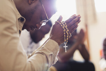 Mann betet mit Rosenkranz in Gebetsgruppe - CAIF22565