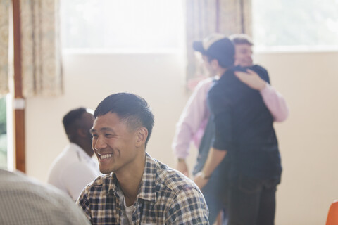 Lächelnder Mann in der Gruppentherapie, lizenzfreies Stockfoto