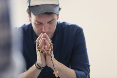 Mann betend mit Rosenkranz - CAIF22571