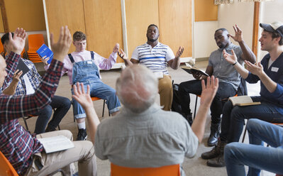 Men praying with arms raised in prayer group - CAIF22582