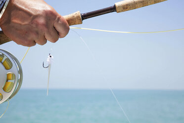 Hand of a fly fisherman preparing to cast for tarpon in Florida, USA - MINF09892