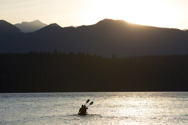 A couple sitting in a sit-on- top Kayak paddling in Puget Sound near the Olympic Mountains in Washington State, USA. - MINF09897