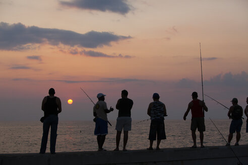 Fischer, die ihr Glück versuchen, stehen auf der Reling der Hafenmauer des Malecon in Havanna, Kuba - MINF09898