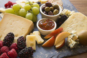 A closeup of a collection of fruits and cheeses. - MINF09920