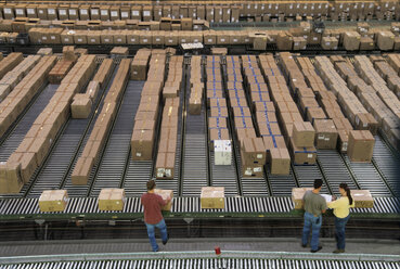 Overview of a large industrial distribution warehouse storing products in cardboard boxes on conveyor belts and racks. - MINF09953