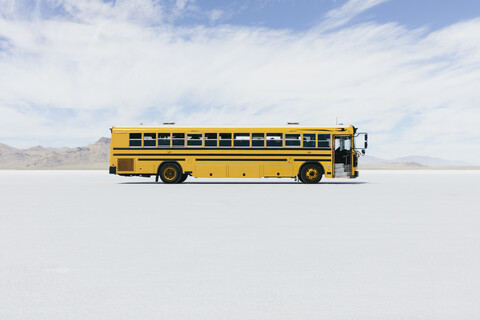 Gelber Schulbus fährt auf Salt Flats, lizenzfreies Stockfoto