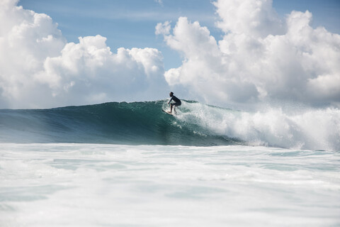 Indonesien, Bali, Serangan, Surfer auf einer Welle, lizenzfreies Stockfoto