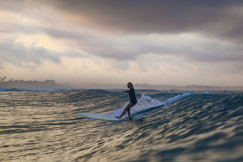 Indonesien, Bali, Canggu, Surferin auf einer Welle - KNTF02590