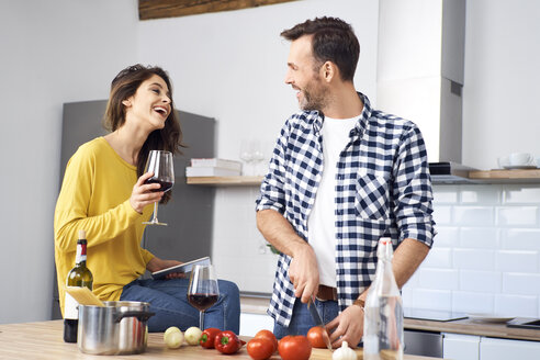 Zärtliches Paar in der Küche, das gemeinsam Spaghetti zubereitet und roten Wein trinkt - BSZF00843