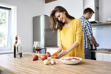 Affectionate couple in kitchen, preparing spaghetti toghether - BSZF00858