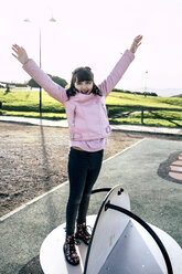Porträt eines Mädchens mit rosa Lederjacke auf einem Spielplatz - MGOF03928