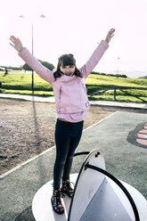 Portrait of girl wearing pink leather jacket on playground - MGOF03928