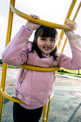 Portrait of girl with tooth gap wearing pink leather jacket on playground - MGOF03929