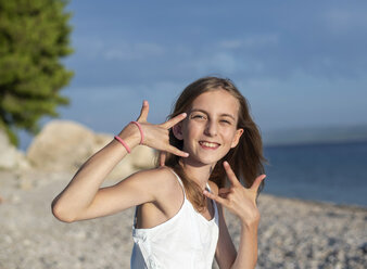 Kroatien, Lokva Rogoznica, Porträt eines gestikulierenden Mädchens am Strand - BFRF01958